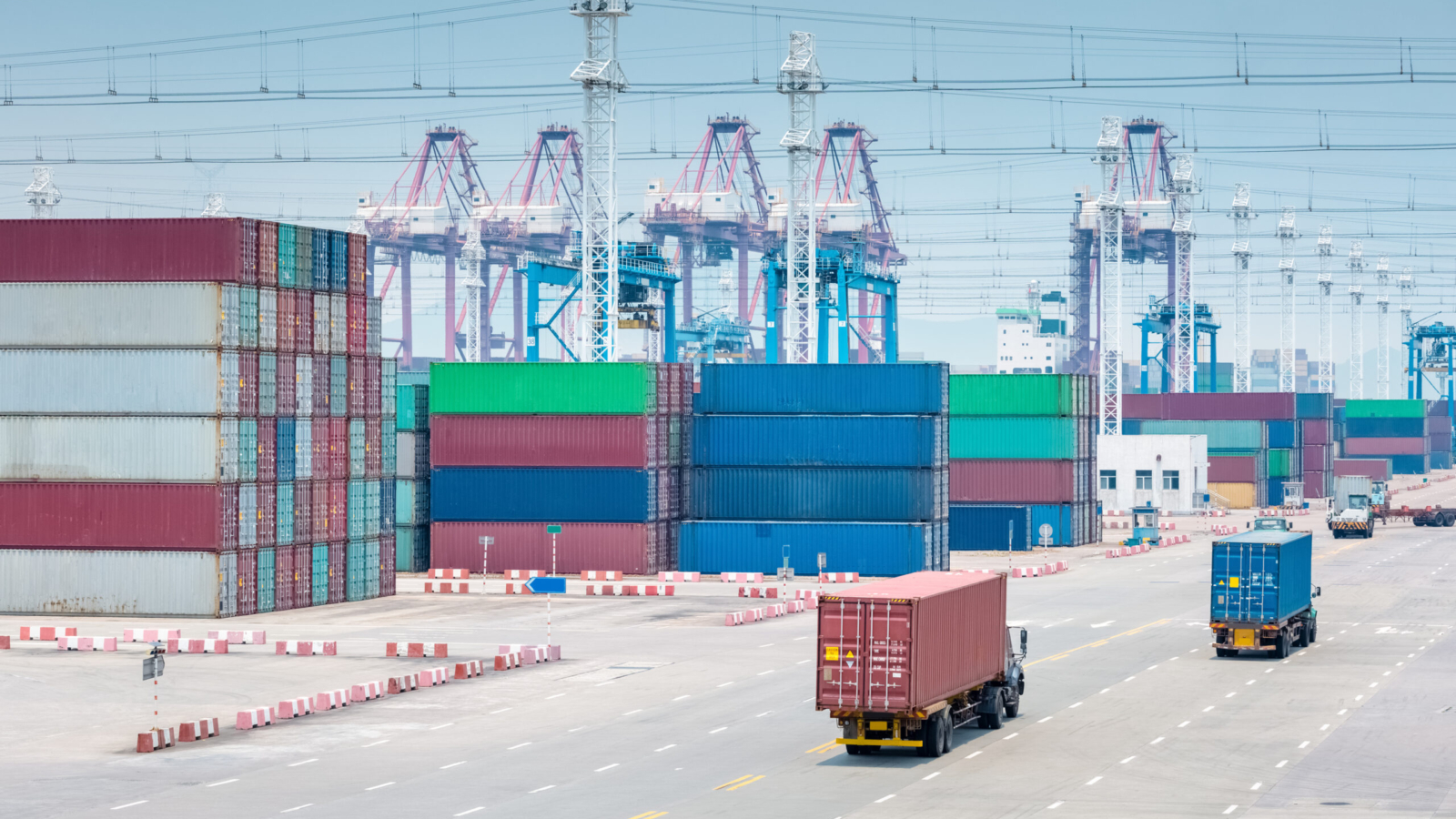 busy container terminal closeup, trucks in transshipment area